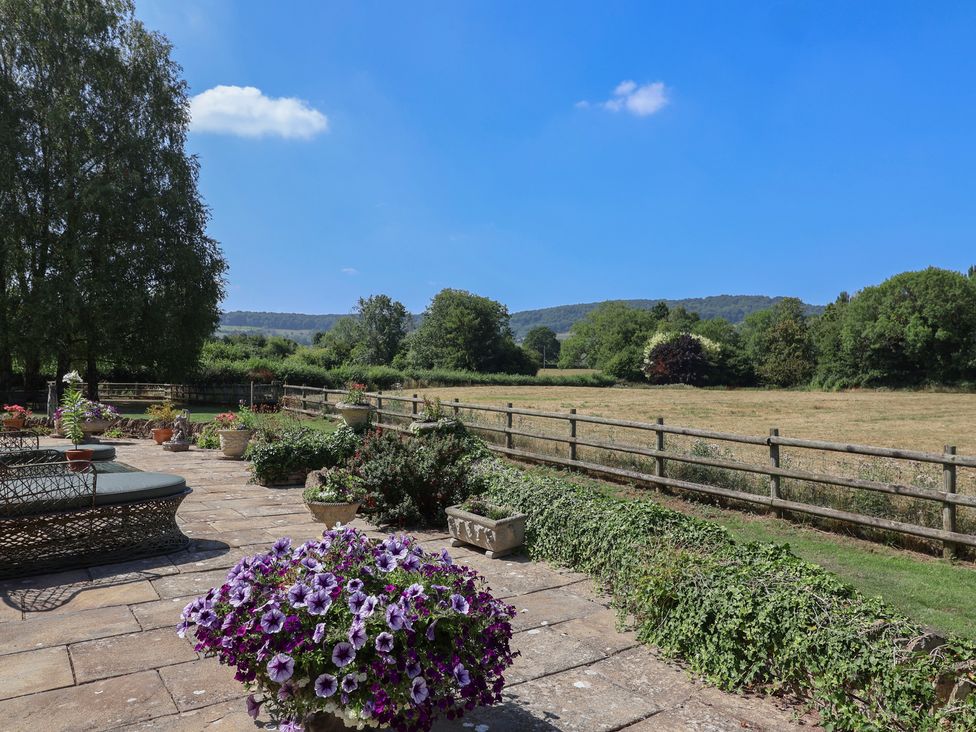 An outdoor area with flowers and a fence at Leafield Cottage in Brockworth
