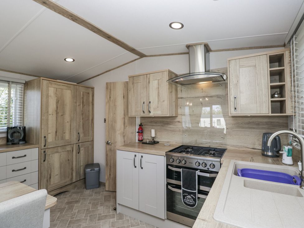 A kitchen with cabinets and appliances at Grasmoor View Lodge