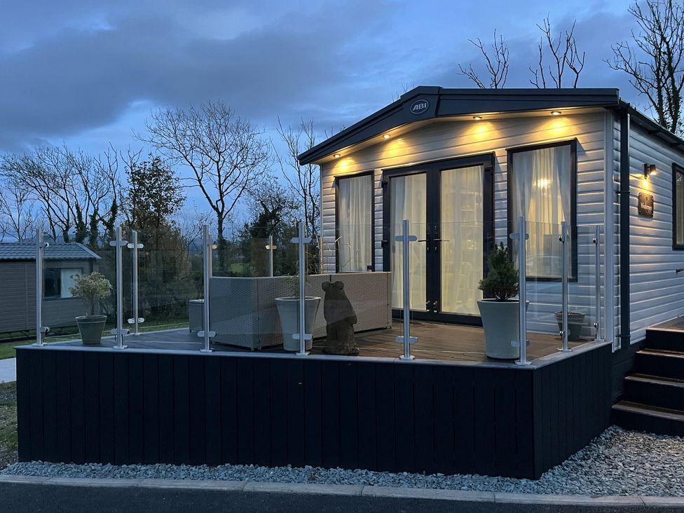 A mobile home with a deck and glass railing at Winscales Rest in Winscales