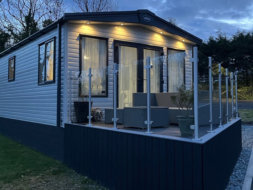 A caravan with a deck and outdoor furniture at Winscales Rest in Winscales