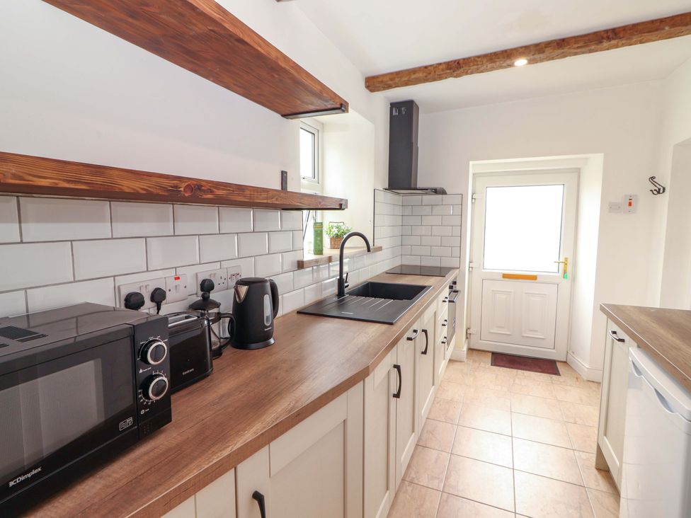 A kitchen with a sink and microwave at The Farmhouse in Tralee, County Kerry