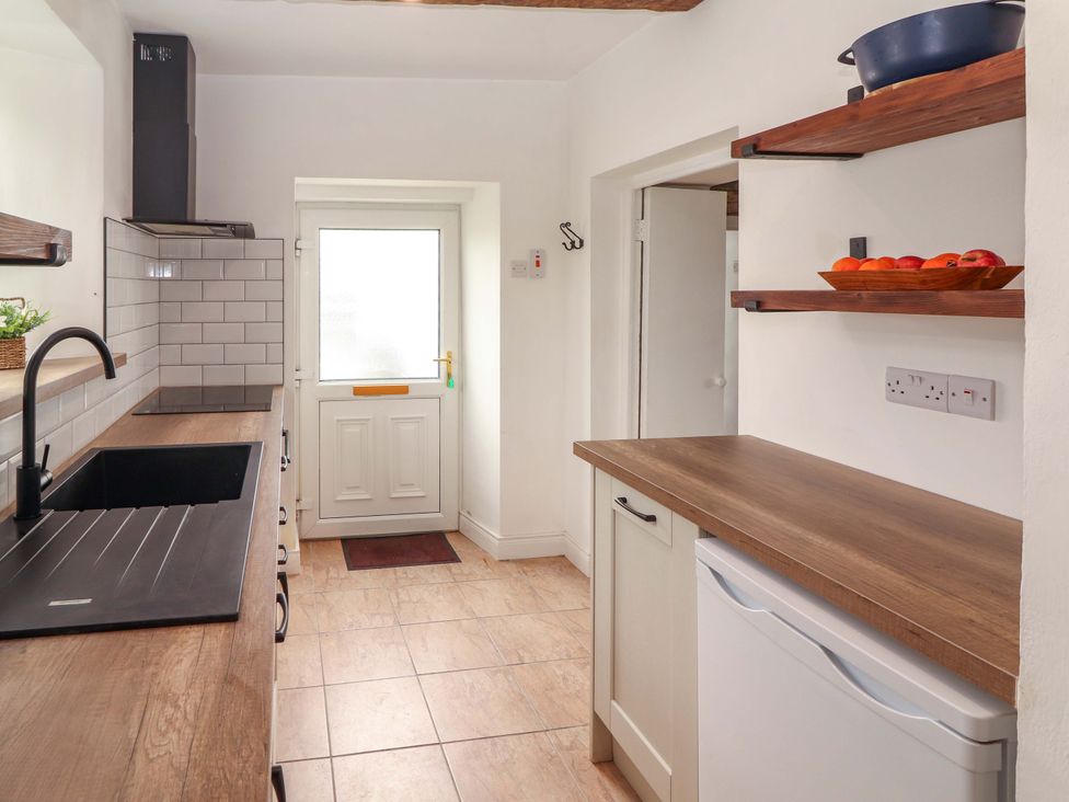A kitchen with a sink and door at The Farmhouse in Tralee, County Kerry