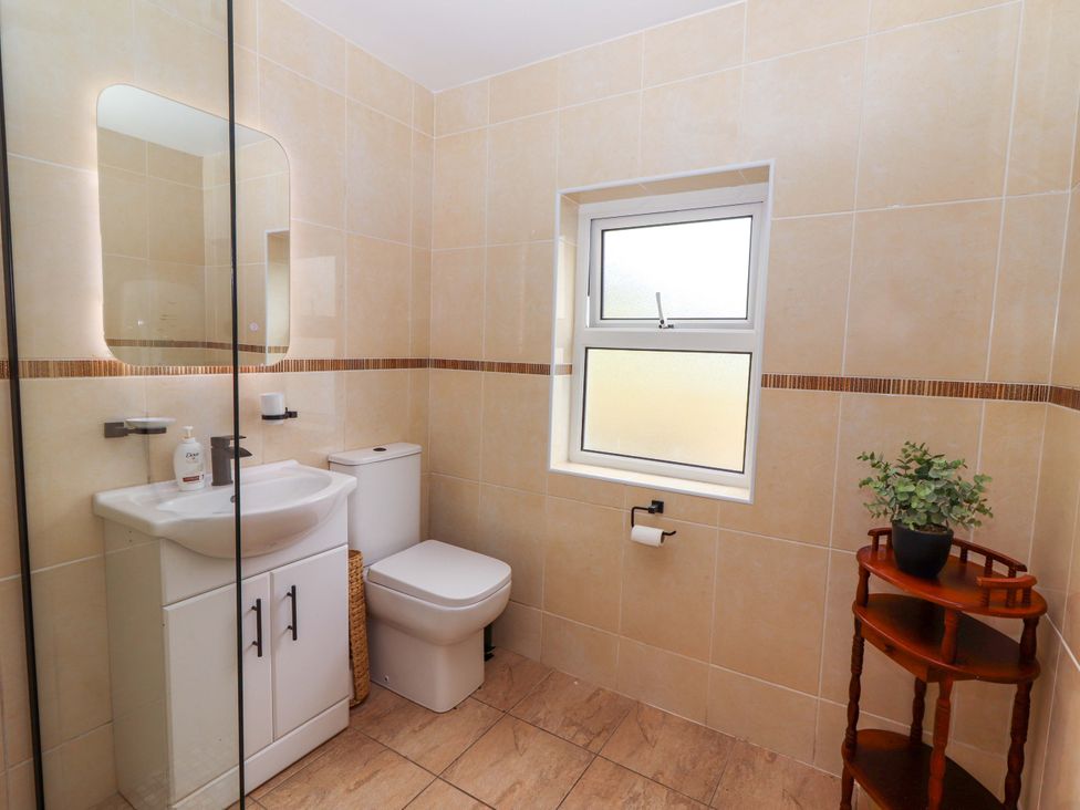 A bathroom with a toilet and sink at The Farmhouse in Tralee, County Kerry