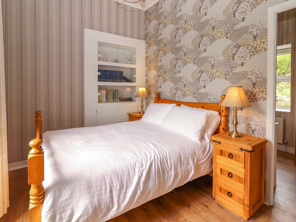 A bedroom with a bed and nightstand at The Farmhouse in Tralee, County Kerry