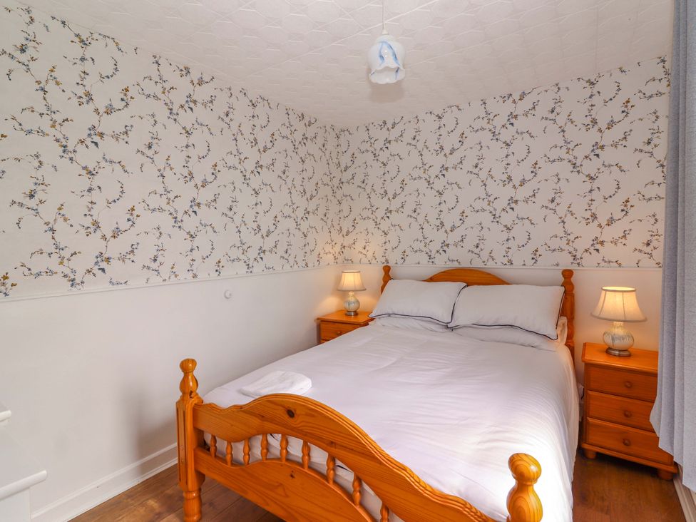 A bedroom with a bed and nightstands at The Farmhouse in Tralee, County Kerry