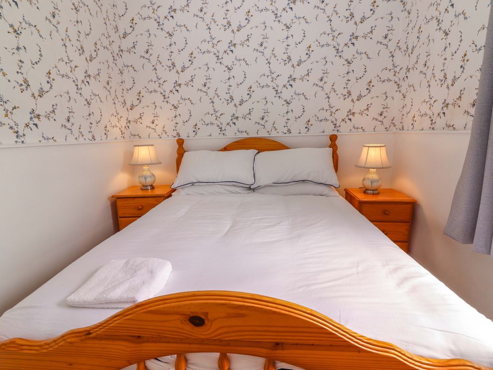 A bedroom with a bed and bedside tables at The Farmhouse in Tralee, County Kerry
