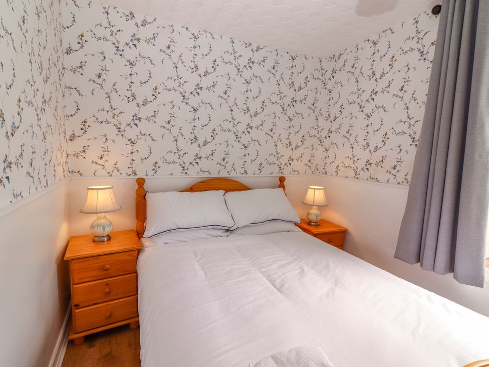 A bedroom with a bed and nightstands at The Farmhouse in Tralee, County Kerry