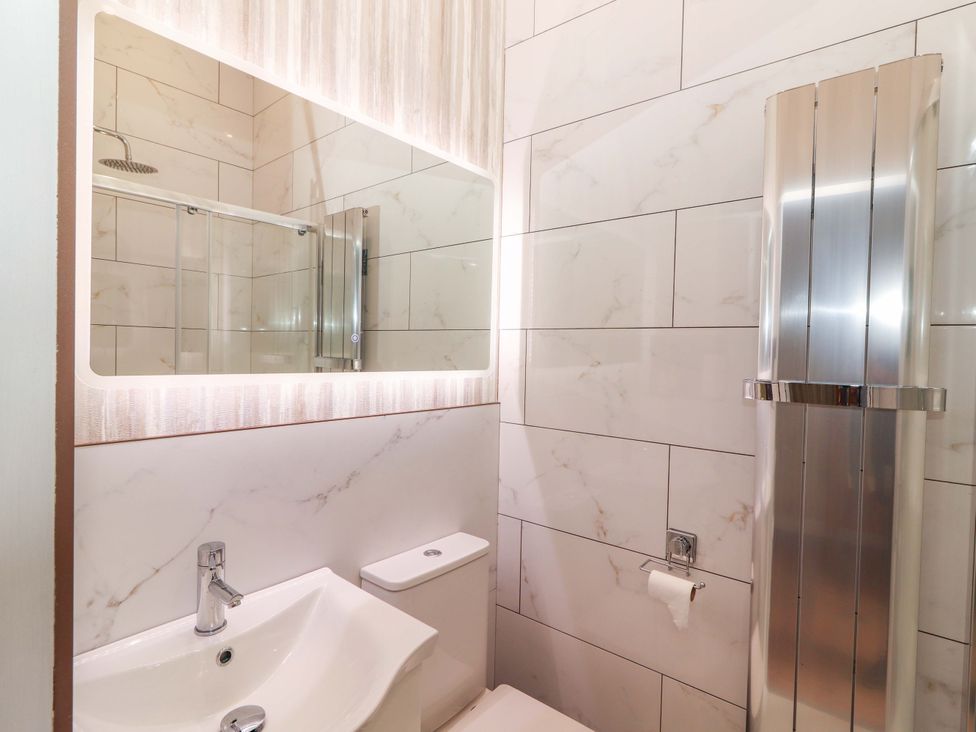 A bathroom with a sink, toilet, shower and mirror at The Farmhouse in Tralee, County Kerry