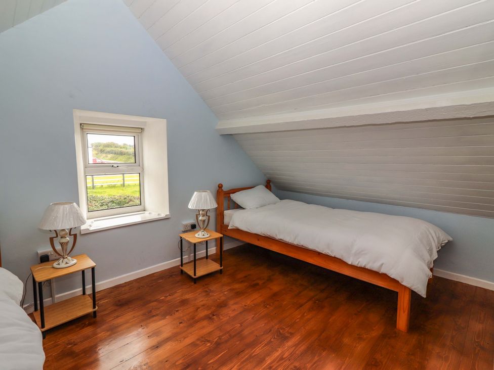 A bedroom with a bed and nightstands at The Farmhouse in Tralee, County Kerry