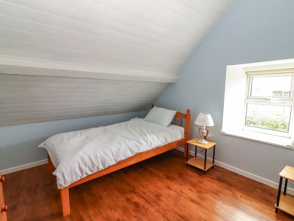 A bedroom with a bed and nightstands at The Farmhouse in Tralee, County Kerry