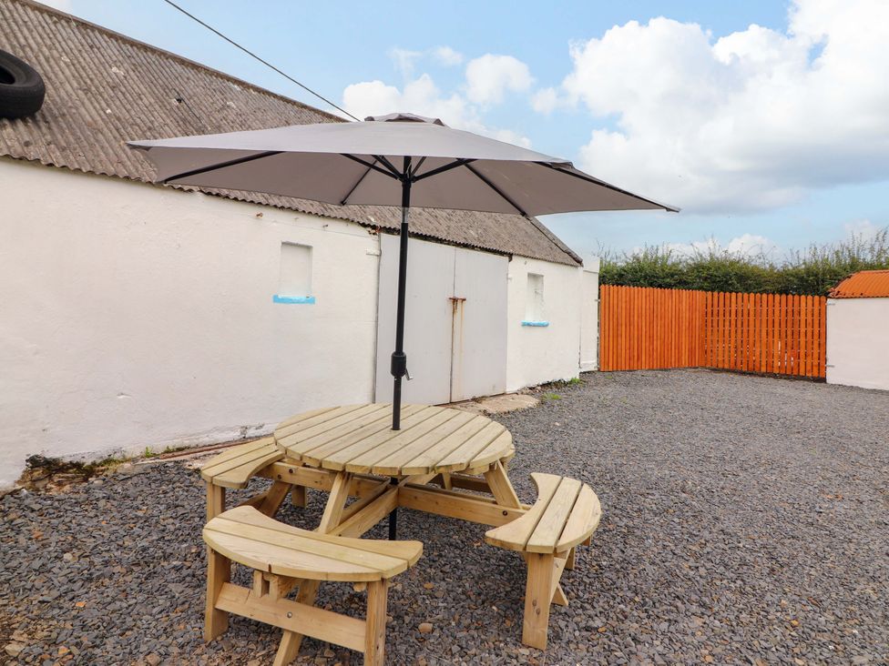 An outdoor area with a picnic table and umbrella at The Farmhouse in Tralee, County Kerry