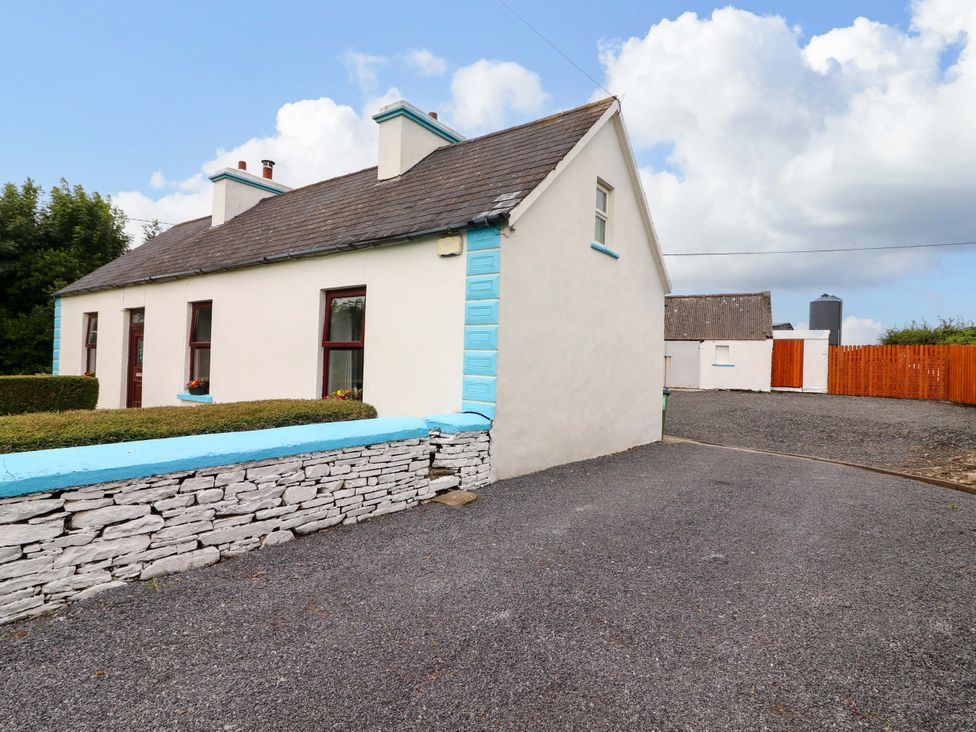 A house with a stone wall and gravel driveway at The Farmhouse in Tralee, County Kerry