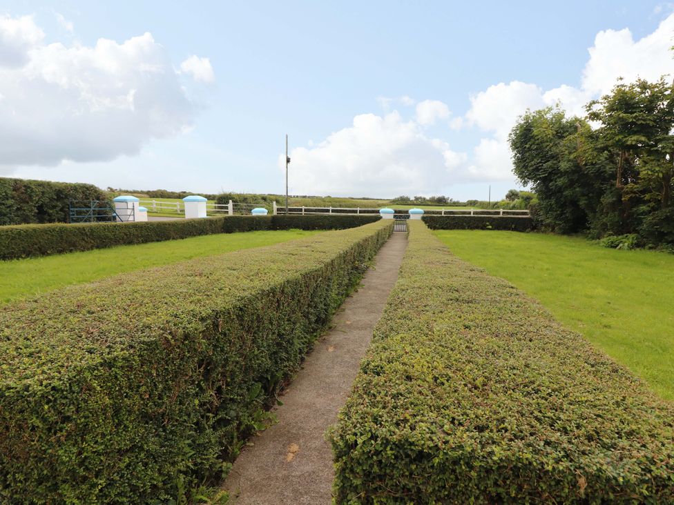 An outdoor area with hedges and a pathway at The Farmhouse in Tralee, County Kerry