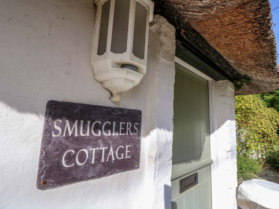 A sign with the name Smugglers Cottage at Smugglers Cottage in New Milton
