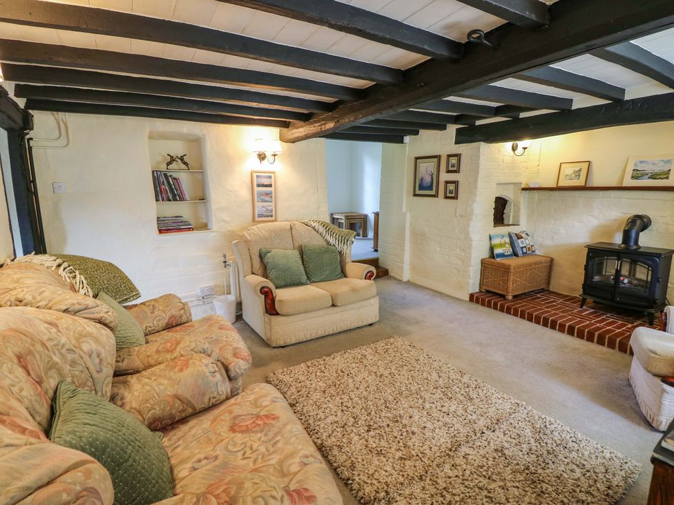 A living room with a sofa and fireplace at Smugglers Cottage in New Milton