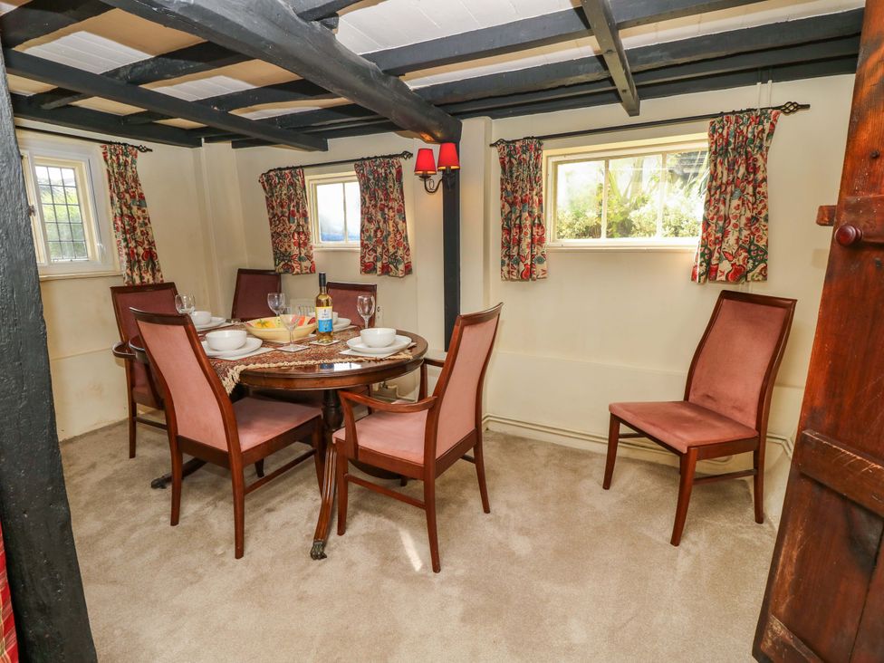 A dining room with a table and chairs at Smugglers Cottage in New Milton