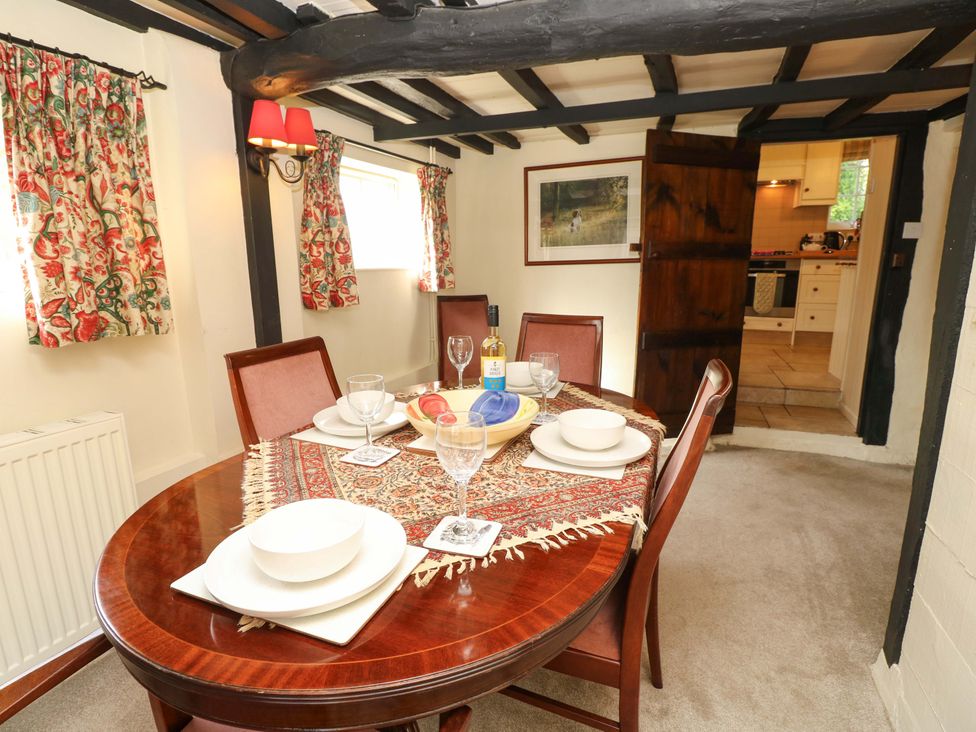 A dining room with a table set for a meal at Smugglers Cottage in New Milton