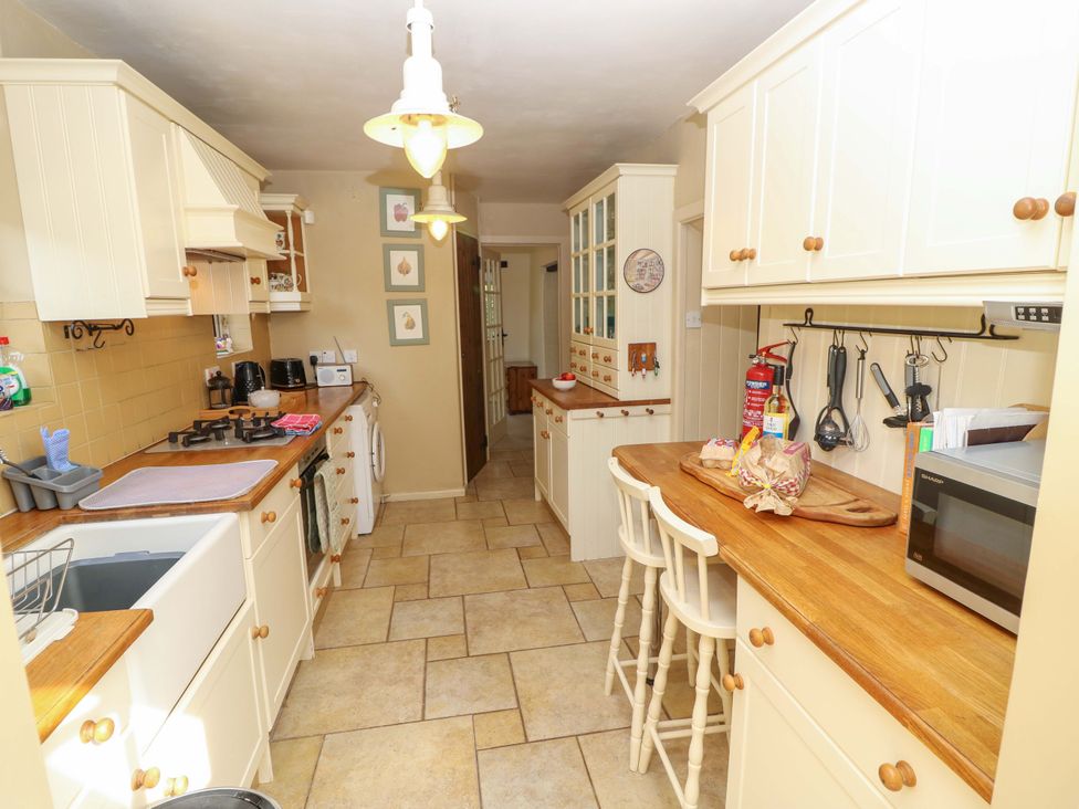 A kitchen with cabinets and appliances at Smugglers Cottage in New Milton