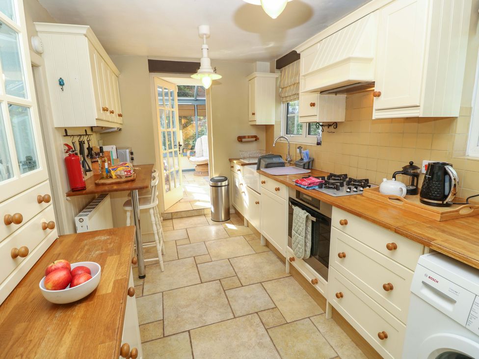 A kitchen with appliances and a view of the garden at Smugglers Cottage in New Milton
