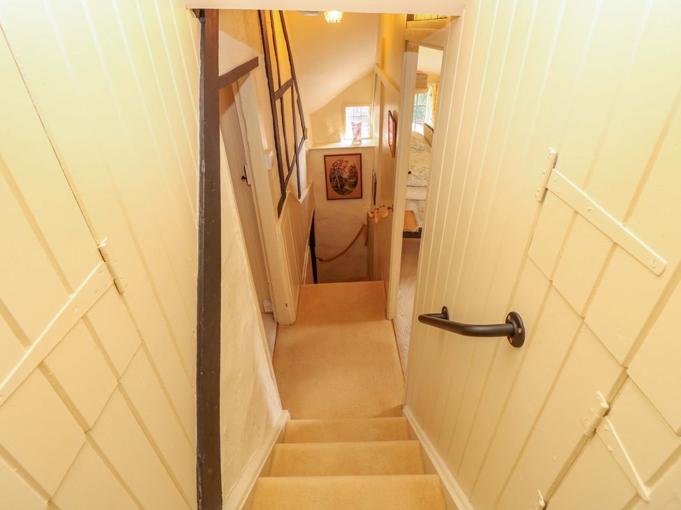 A stairwell with stairs and a handrail at Smugglers Cottage in New Milton