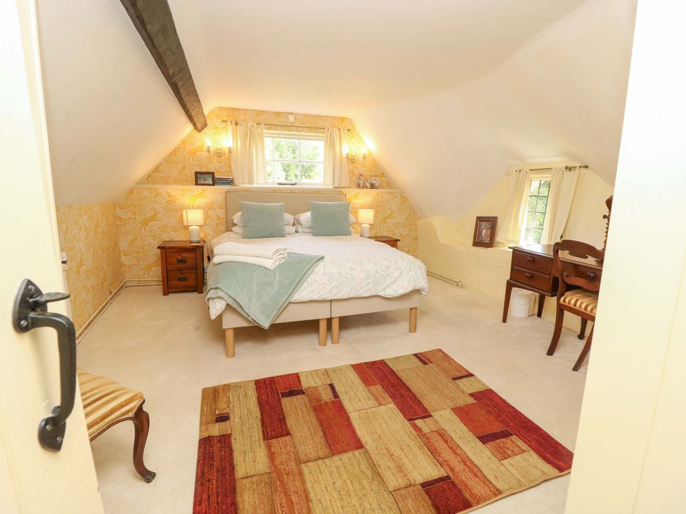 A bedroom with a bed and nightstand at Smugglers Cottage in New Milton