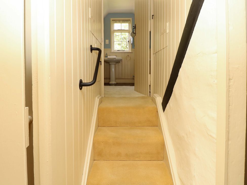 A staircase leading to a toilet in the hallway at Smugglers Cottage in New Milton