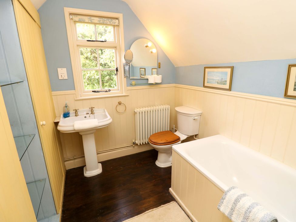 A bathroom with a sink, toilet, and bath at Smugglers Cottage in New Milton