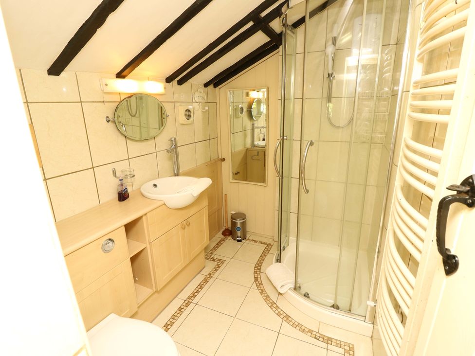 A bathroom with a shower and sink at Smugglers Cottage in New Milton