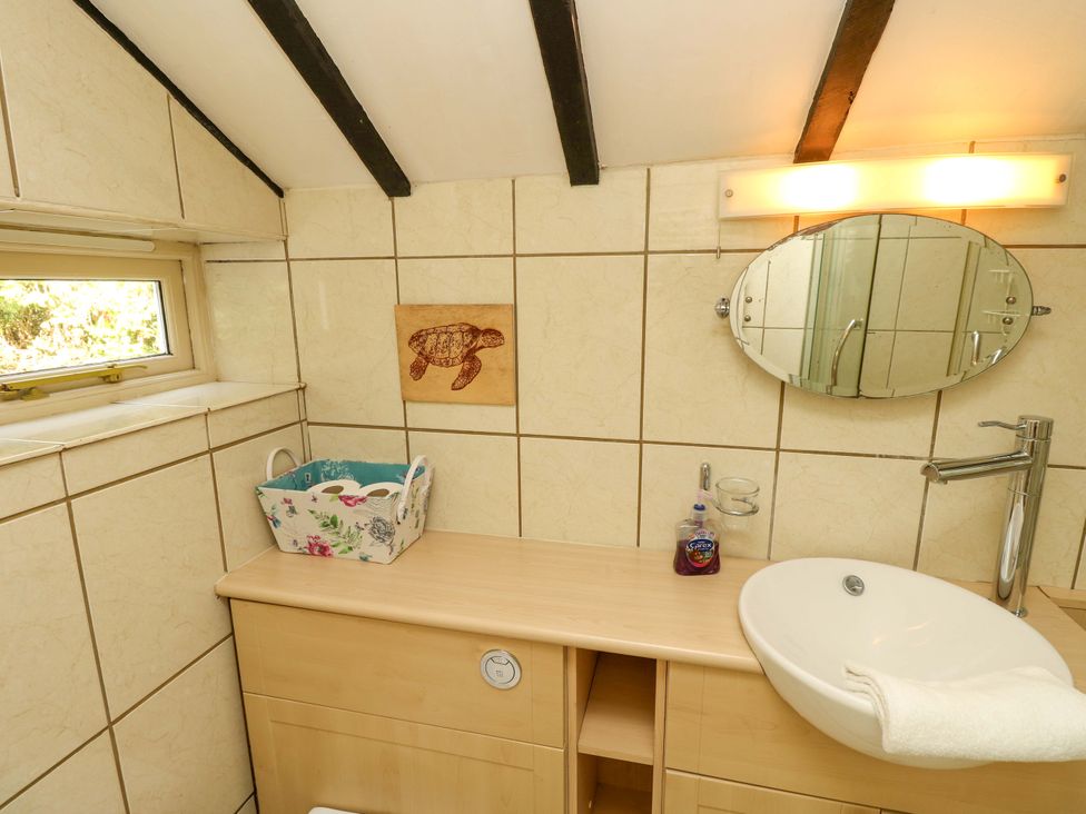 A bathroom with sink and mirror at Smugglers Cottage in New Milton