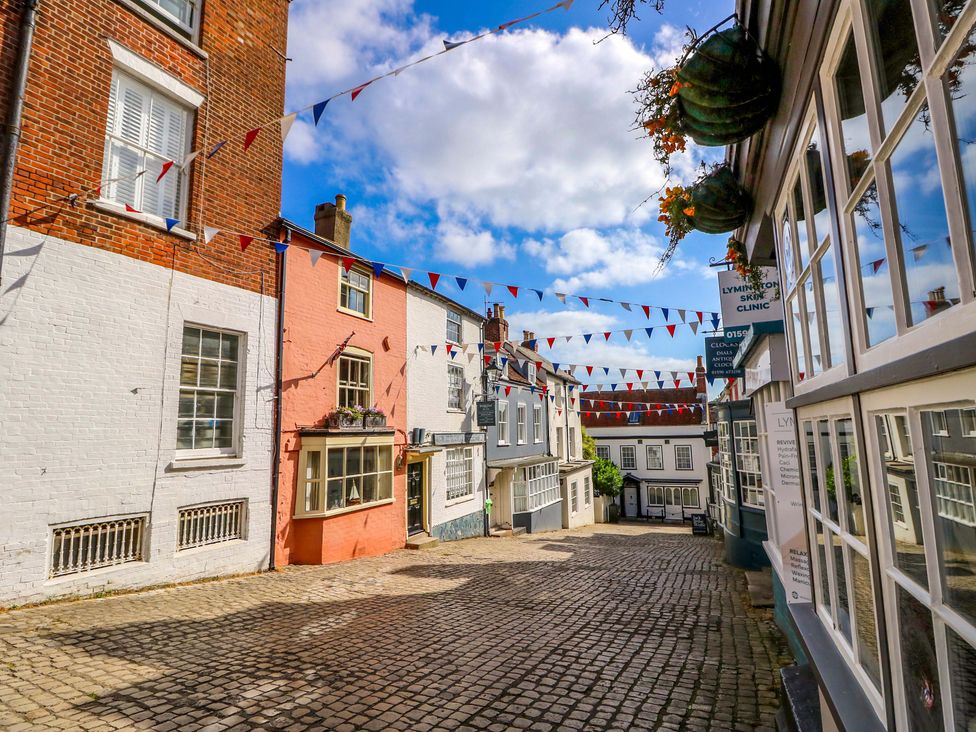 A street with buildings and bunting at Smugglers Cottage in New Milton