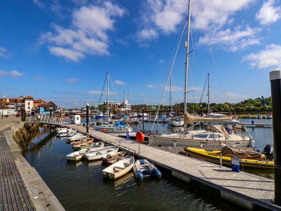 A marina with boats and a dock at Smugglers Cottage in New Milton