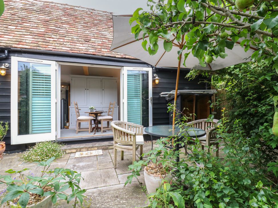 An outdoor seating area with a table and chairs at Little Barn @ Orwell