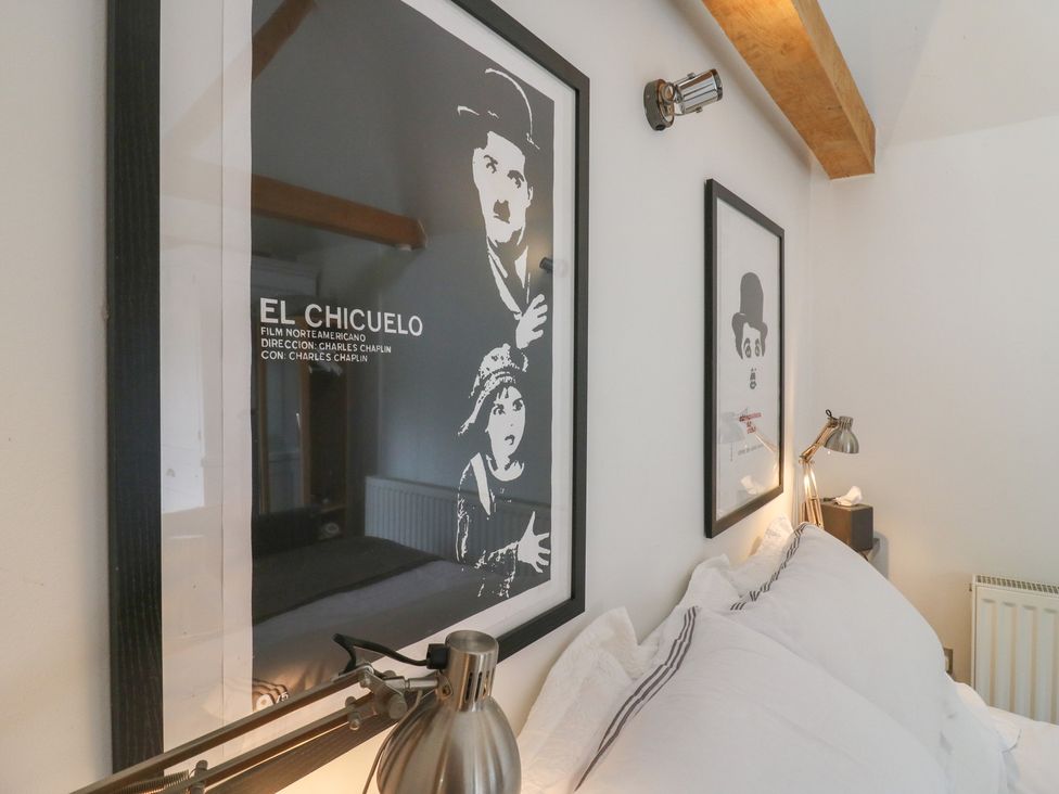A bedroom with framed wall art and bedside lamp at Little Barn @ Orwell