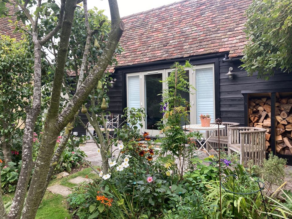 A garden with flowers and seating area at Little Barn Orwell