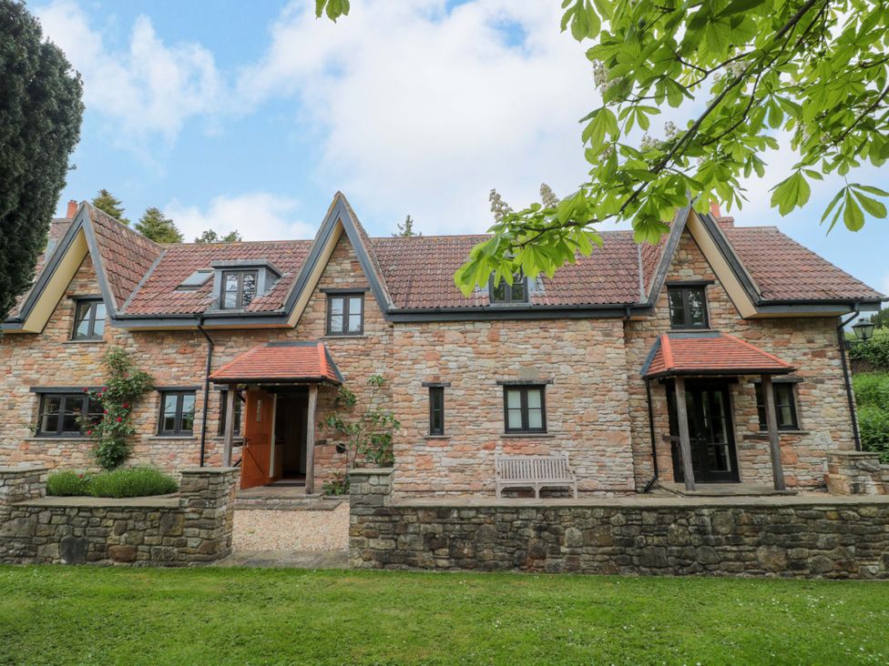 A house with stone walls and a garden at Stowey Mead Stables Bishop Sutton