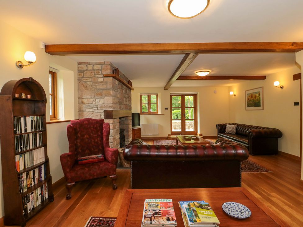 A living room with a fireplace and two sofas at Stowey Mead Stables in Bishop Sutton
