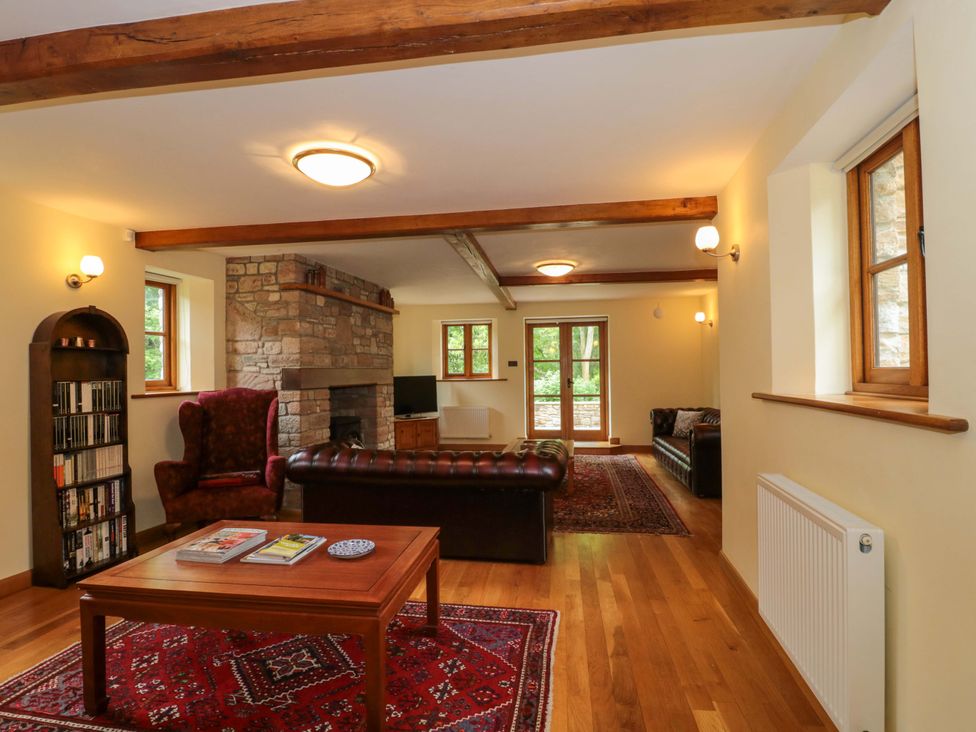 A living room with a fireplace and seating at Stowey Mead Stables in Bishop Sutton