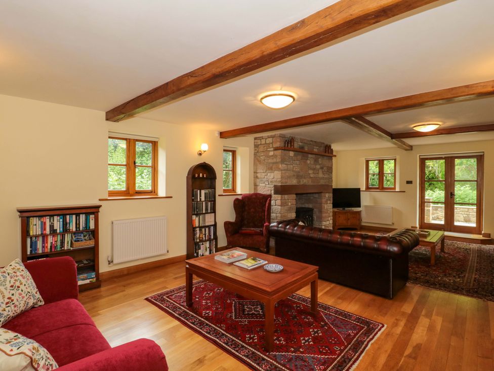 A living room with a fireplace and bookshelf at Stowey Mead Stables Bishop Sutton
