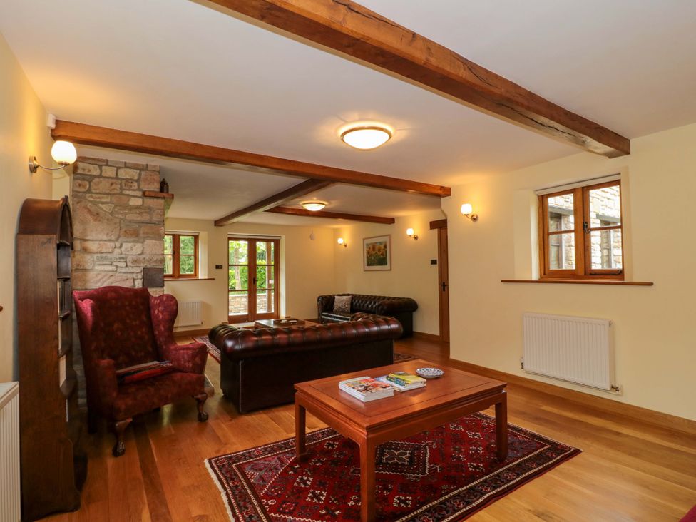 A living room with an armchair and a coffee table at Stowey Mead Stables in Bishop Sutton
