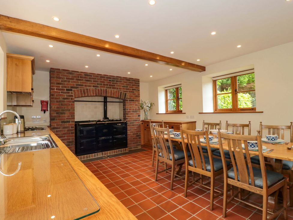 A kitchen with a dining table and oven at Stowey Mead Stables Bishop Sutton