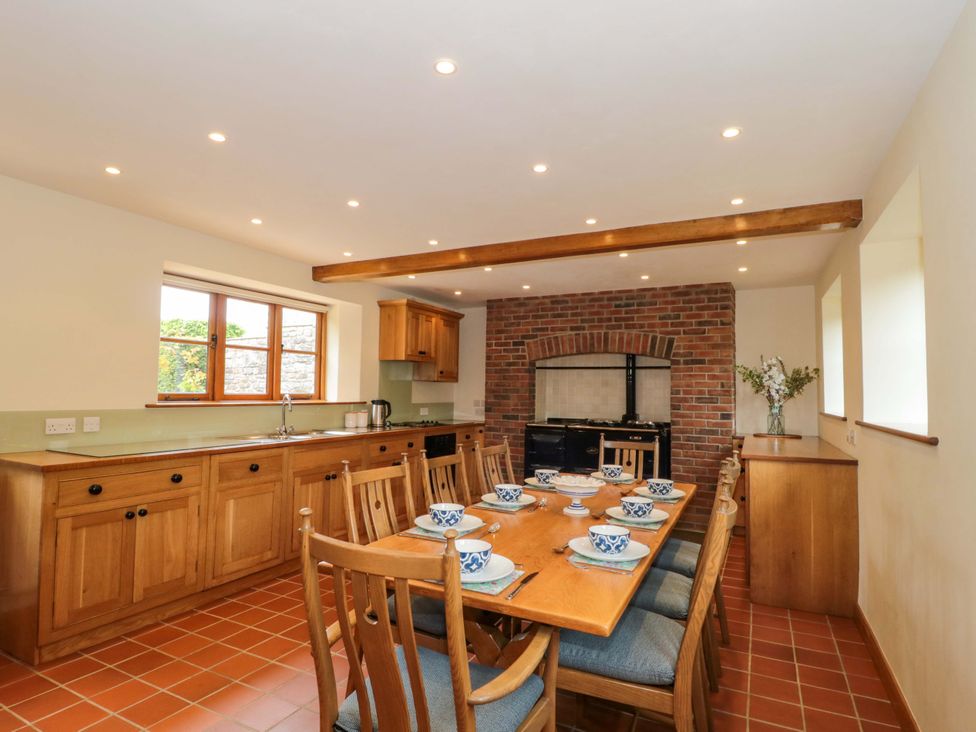 A kitchen with a dining table and chairs at Stowey Mead Stables in Bishop Sutton
