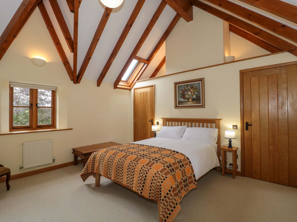 A bedroom with a bed and bedside tables at Stowey Mead Stables in Bishop Sutton