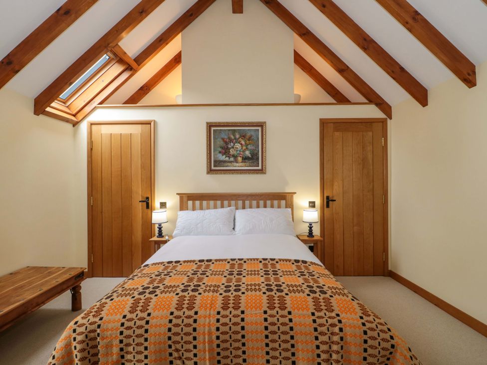 A bedroom with a bed and two doors at Stowey Mead Stables in Bishop Sutton