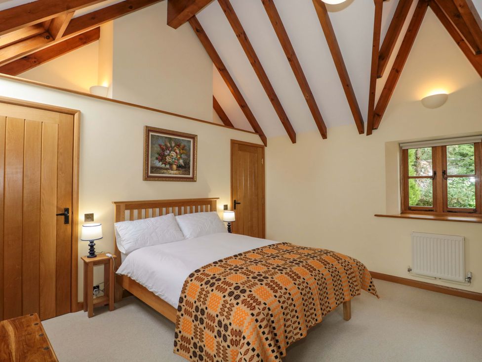 A bedroom with a bed and a window at Stowey Mead Stables in Bishop Sutton
