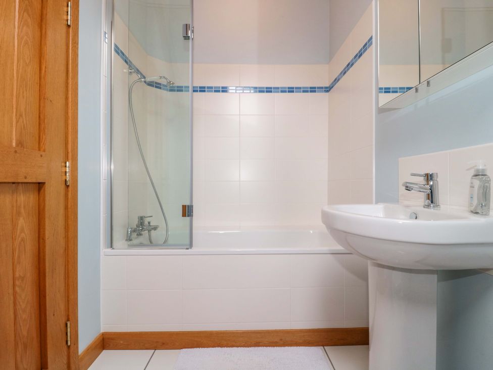 A bathroom featuring a shower and tub at Stowey Mead Stables in Bishop Sutton
