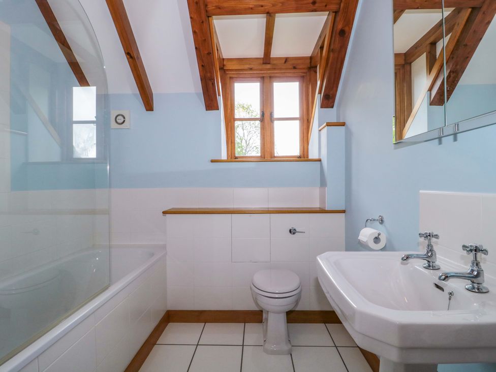 A bathroom with a bath, toilet, and sink at Stowey Mead Stables Bishop Sutton