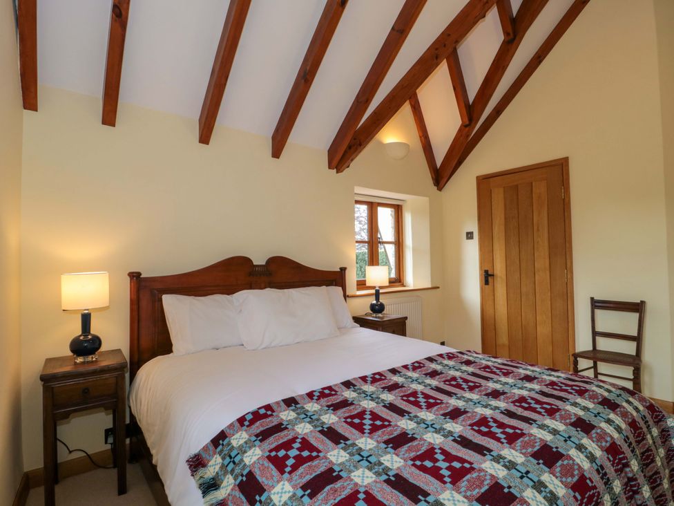 A bedroom with a bed and bedside lamp at Stowey Mead Stables in Bishop Sutton