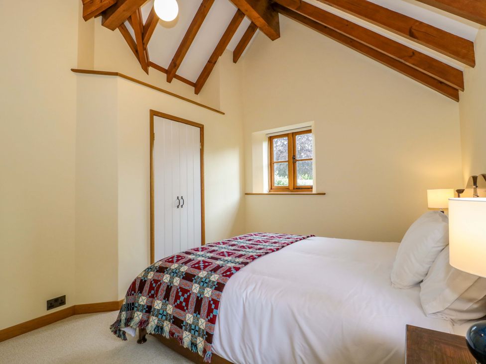 A bedroom with a bed and a window at Stowey Mead Stables in Bishop Sutton