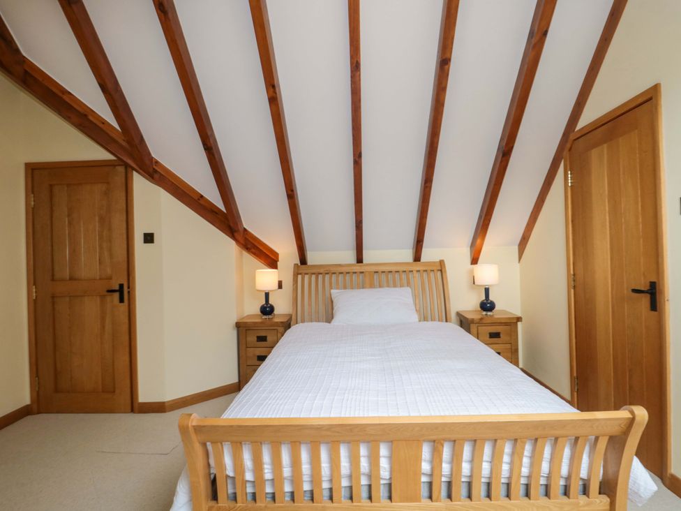A bedroom with a bed and nightstands at Stowey Mead Stables Bishop Sutton