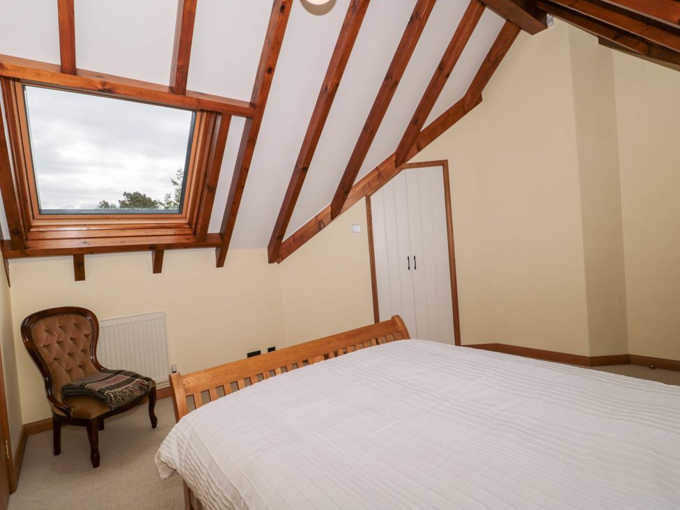 A bedroom with a bed and a chair at Stowey Mead Stables in Bishop Sutton